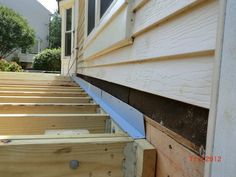 the side of a house that is being built with wood planks and siding on it