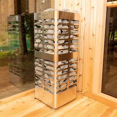 a large metal object sitting on top of a wooden floor next to a window with glass doors