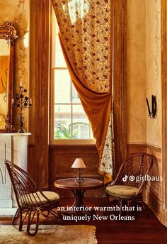 a living room with two chairs and a table in front of a window that says, an interior warmth that is uniquely new orleans