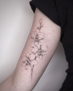 a woman's arm with a flower tattoo on the left side of her arm