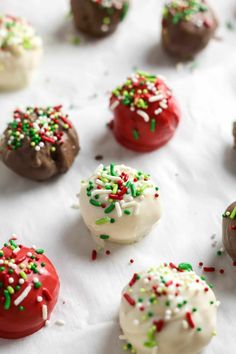 chocolate covered donuts with sprinkles and white frosting on a table