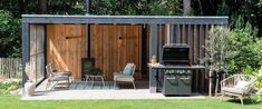 an outdoor kitchen with grill and chairs