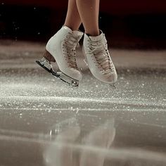 a person in white shoes is skating on ice