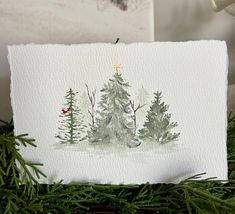 a christmas card with watercolor trees on it