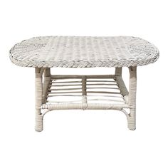 a white wicker table with an oval design on the top and bottom, against a white background