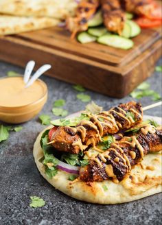 chicken skewers with sauce and vegetables on a tortilla