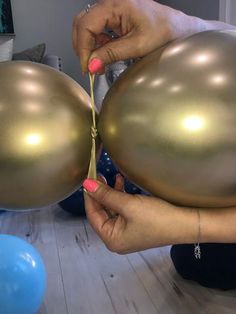 a woman is holding two large balloons in her hands, while another person holds the balloon