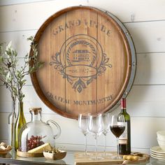 a wine barrel sitting on top of a table next to bottles and glasses filled with wine