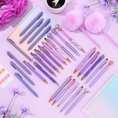 the purple pens are lined up next to each other on top of a pink table