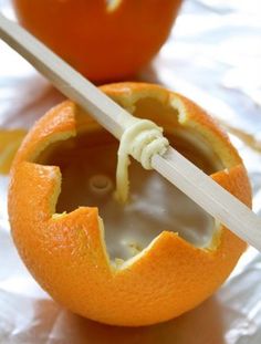 an orange cut in half with a knife sticking out of the center and inside it