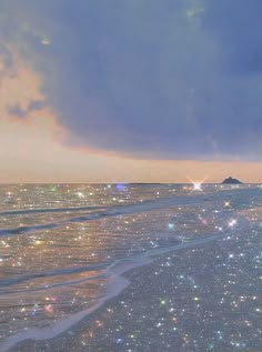 the sky is filled with stars on the beach and waves are coming in to shore