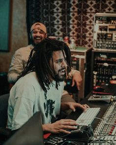 two men sitting in front of a mixing desk