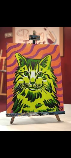 a painting of a green cat on an easel in front of a red and purple background