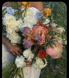 a woman holding a bouquet of flowers in her hands