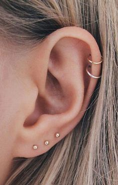 a close up of a person's ear with two piercings on the side