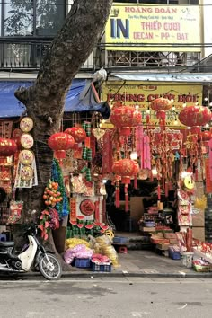 a motorcycle parked in front of a store with lanterns hanging from it's roof