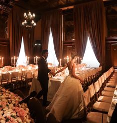 a bride and groom standing in front of a table