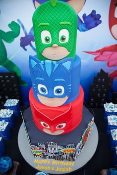 the birthday cake is decorated like batmans and catwoman's faces on it