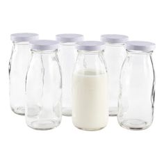 six glass jars with white lids are lined up next to each other