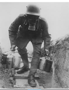 a man wearing a gas mask and holding two buckets while walking up some steps