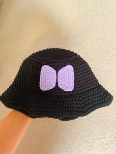 a crocheted black hat with purple ears