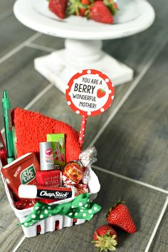 a basket filled with lots of food on top of a wooden floor next to strawberries