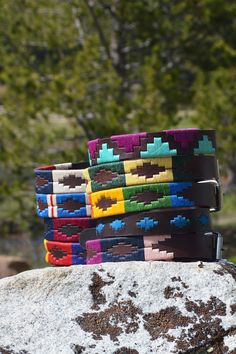 several colorful belts sitting on top of a rock