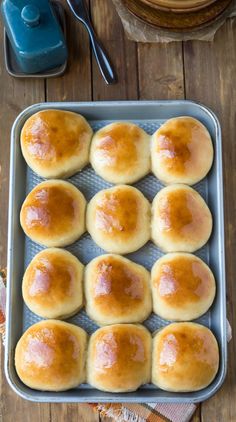 freshly baked rolls in a baking pan on a wooden table