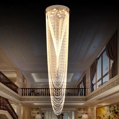 a large chandelier hanging from the ceiling in a living room next to stairs