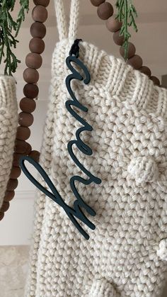 a crocheted bag hanging from a hook on a wall with the word welcome