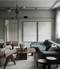 a living room filled with lots of furniture next to large windows on either side of the wall