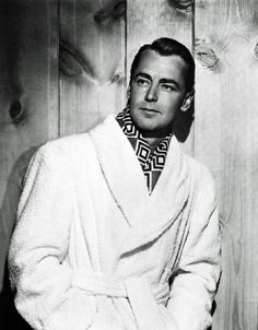 a man in a bathrobe poses for a photo