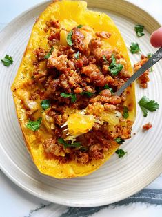 a white plate topped with a stuffed squash covered in meat and vegtables