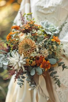 a bridal holding a bouquet of flowers and greenery