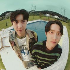 two young men standing next to each other in front of a pool