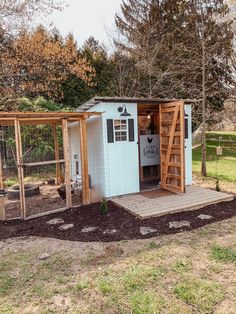 a chicken coop in the middle of a yard with steps leading up to it's door