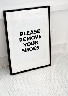 a black and white poster with the words please remove your shoes on it next to a toilet