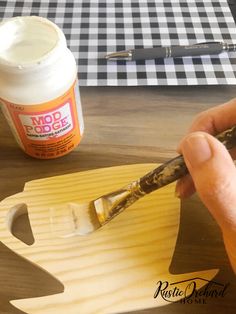 someone is painting the letters on a wooden letter with acrylic paint and a brush