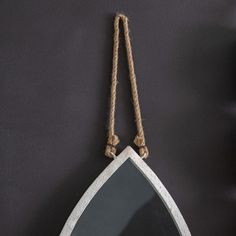 a mirror hanging from a rope on the wall