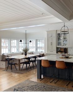 an open kitchen and dining room with white cabinets