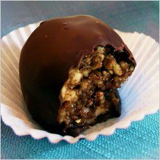 a chocolate covered dessert sitting on top of a white paper cupcake wrapper next to a blue table cloth