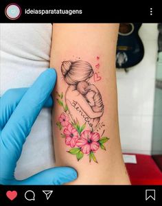 a woman's arm with a tattoo on it that has flowers and a heart