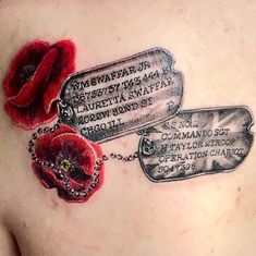 a woman's chest with three tags and two red poppies on it,