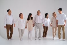 a group of people standing next to each other in front of a white background,