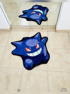 two blue rugs with cartoon characters on them in front of a door and tiled floor