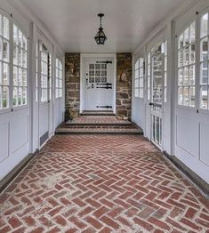 a brick walkway leads to the front door of a house with white doors and windows