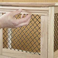 a hand is reaching for the top of a cabinet with a chain link design on it