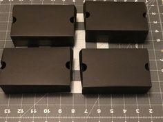 four pieces of black plastic sitting on top of a cutting board with numbers and symbols