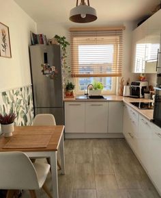 a kitchen with white cabinets and wooden floors