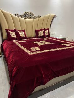 a bed with a red comforter and matching pillows